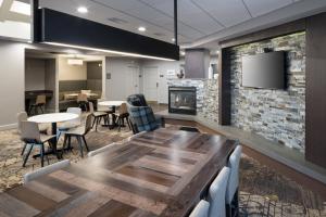 uma sala de conferências com uma mesa e cadeiras e uma lareira em Residence Inn Boston Westford em Westford