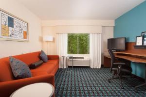 a hotel room with a couch and a desk and a computer at Fairfield Inn Charlotte Gastonia in Gastonia