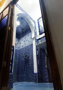 a blue bathroom with a shower and a sink at Dar Mora in Tangier