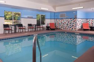 einen Pool mit Stühlen und Tischen in einem Gebäude in der Unterkunft Fairfield Inn Charlotte Gastonia in Gastonia