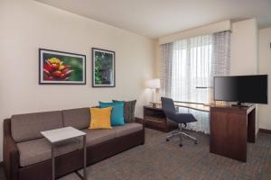 sala de estar con sofá, escritorio y TV en Residence Inn by Marriott Boston Braintree, en Braintree
