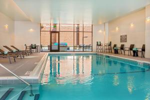 uma piscina num hotel com cadeiras e mesas em Residence Inn by Marriott Boston Braintree em Braintree