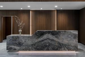 - une grande table en marbre dans une chambre dotée de murs en bois dans l'établissement AC Hotel by Marriott Bozeman Downtown, à Bozeman