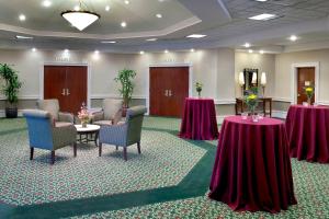 a conference room with two tables and chairs and flowers at SpringHill Suites Boston Peabody in Peabody