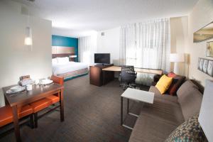a hotel room with a bed and a living room at Residence Inn by Marriott Augusta in Augusta
