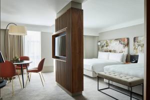 a hotel room with a bed and a table and chairs at London Marriott Hotel Kensington in London +51 photos