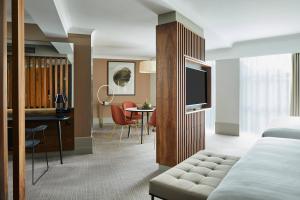 ロンドンにあるロンドン マリオット ホテル ケンジントンのベッドとダイニングルームが備わるホテルルームです。