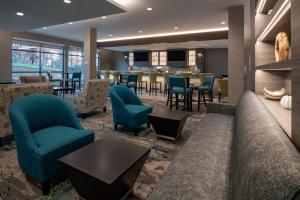 a lobby of a hotel with blue chairs and tables at SpringHill Suites By Marriott Wrentham Plainville in Wrentham
