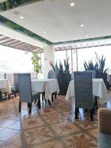 a dining room with white tables and chairs and plants at Terramistica Vallecito in Arequipa