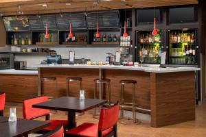 a bar in a restaurant with red chairs and tables at Courtyard Houston NW/290 Corridor in Houston