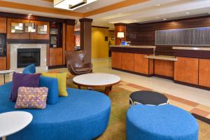 a living room with a blue couch and tables at Fairfield Inn and Suites by Marriott Birmingham / Bessemer in Bessemer