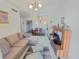 a living room with a couch and a tv at San Stefano Grand Plaza in Alexandria