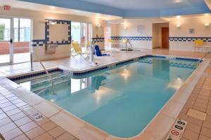 Fairfield Inn and Suites by Marriott Birmingham / Bessemer في بسمر: مسبح كبير مع ماء أزرق في غرفة الفندق