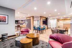 a lobby with tables and chairs and a bar at TownePlace Suites by Marriott Chicago Waukegan Gurnee in Waukegan