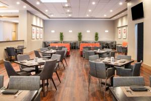 uma sala de jantar com mesas e cadeiras em Delta Hotels by Marriott Detroit Metro Airport em Romulus