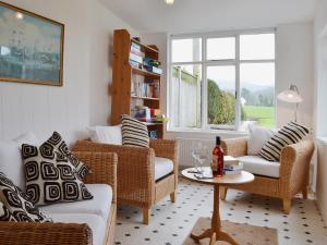 a living room with wicker chairs and a table at The Old Post Office in Myddfai