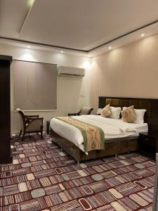 a bedroom with a large bed and a projection screen at فندق مرسى جيزان in Jazan