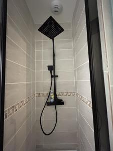 a shower with a shower head in a bathroom at Au 15 - Charmant Studio hyper centre in Saint-Amand-Montrond