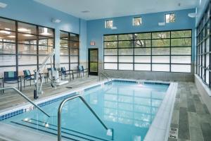 a swimming pool in a building with blue walls and windows at SpringHill Suites by Marriott Topeka Southwest in Topeka