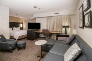 スプリングデールにあるResidence Inn by Marriott Springdaleのソファとベッド付きのホテルルーム