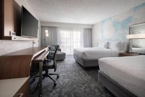 a hotel room with two beds and a desk at Courtyard by Marriott Las Vegas Convention Center in Las Vegas