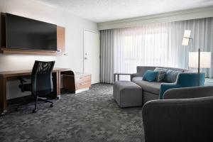 a hotel room with a couch and a desk with a computer at Courtyard by Marriott Las Vegas Convention Center in Las Vegas