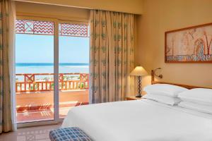 a bedroom with a bed and a view of the ocean at Sheraton Soma Bay Resort in Hurghada