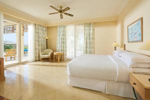 a bedroom with a large white bed and a balcony at Sheraton Soma Bay Resort in Hurghada