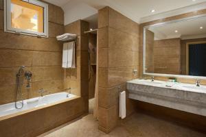 a bathroom with two sinks and a tub and a large mirror at Sheraton Soma Bay Resort in Hurghada