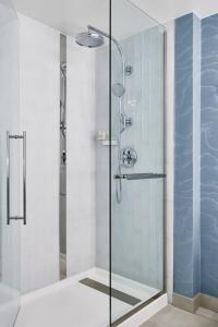 a shower with a glass door in a bathroom at Renaissance Charlotte SouthPark Hotel in Charlotte