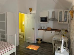 eine Küche mit weißen Schränken und einem Tisch im Zimmer in der Unterkunft Casas da Vista II & I & 0 in Sesimbra