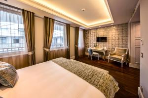a bedroom with a bed and a table and window at Prestige Hotel Budapest in Budapest