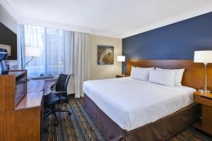 ハーンドンにあるFairfield by Marriott Inn & Suites Herndon Restonのベッド、デスク、テレビが備わるホテルルームです。