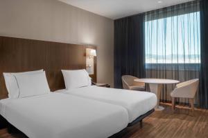 a hotel room with a large bed and a table at AC Hotel Barcelona Fórum by Marriott in Barcelona