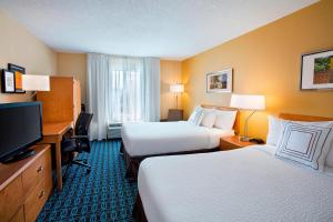 a hotel room with two beds and a desk and a television at Fairfield Inn & Suites Merrillville in Merrillville