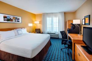 a hotel room with a bed and a flat screen tv at Fairfield Inn & Suites Merrillville in Merrillville