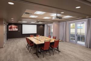 a conference room with a table and chairs and a screen at Courtyard by Marriott Baton Rouge Downtown in Baton Rouge