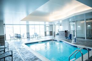 a swimming pool in a building with tables and chairs at Fairfield by Marriott Inn & Suites Kingsport in Kingsport