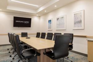 uma sala de conferências com uma mesa de madeira e cadeiras pretas em SpringHill Suites St. Paul Downtown em Saint Paul