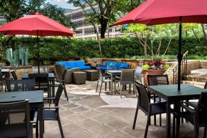 a patio with tables and chairs and red umbrellas at Residence Inn Bethesda Downtown in Bethesda