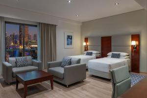 a hotel room with two beds and a living room at Delta Hotels by Marriott Jumeirah Beach, Dubai in Dubai