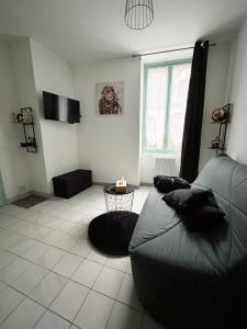 een woonkamer met een bed en een tafel bij Au 15 - Charmant Studio hyper centre in Saint-Amand-Montrond
