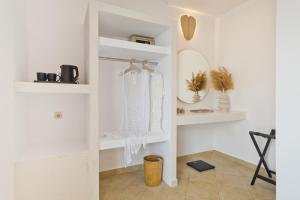 een witte kamer met witte planken en een spiegel bij Diana Art Boutique Hotel in Rhodos-stad