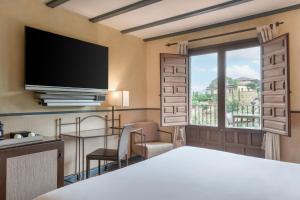 a hotel room with a bed and a large window at AC Hotel Ciudad de Toledo by Marriott in Toledo