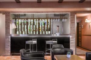 a bar in a restaurant with chairs and wine bottles at AC Hotel Ciudad de Toledo by Marriott in Toledo