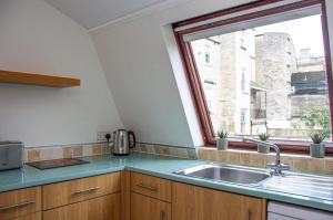 una cucina con lavandino e finestra di Margarets Buildings a Bath