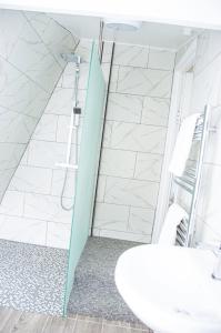 bagno con doccia, lavandino e specchio di Margarets Buildings a Bath