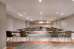 AC Hotel Ciudad de Toledo by Marriott في طليطلة: قاعة اجتماعات فيها طاولات وكراسي