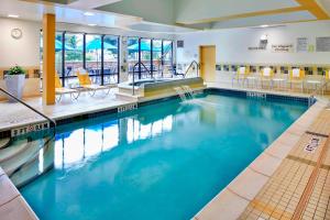 a large swimming pool with blue water in a building at Fairfield Inn & Suites by Marriott Cumberland in Cumberland