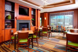 um restaurante com mesas e cadeiras e uma lareira em Fairfield Inn & Suites by Marriott Cumberland em Cumberland